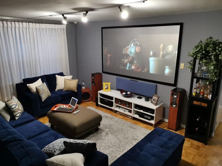 Projection screen with a movie scene displayed in a cozy living room setup.