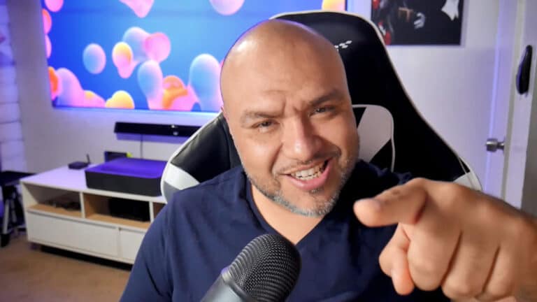 Man pointing at the camera with a confident expression in a modern, tech-savvy room setting.