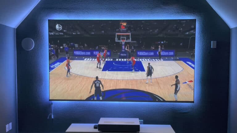 Large home theater projection screen displaying a basketball game.