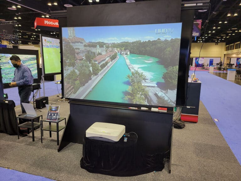 Projection screen displaying a scenic river view at an exhibition.