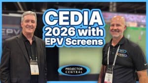 Two men at CEDIA 2026 event showcasing projection screens for home theaters.